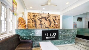En hotellobby med en marmordisk, en soffa och en takfläkt.