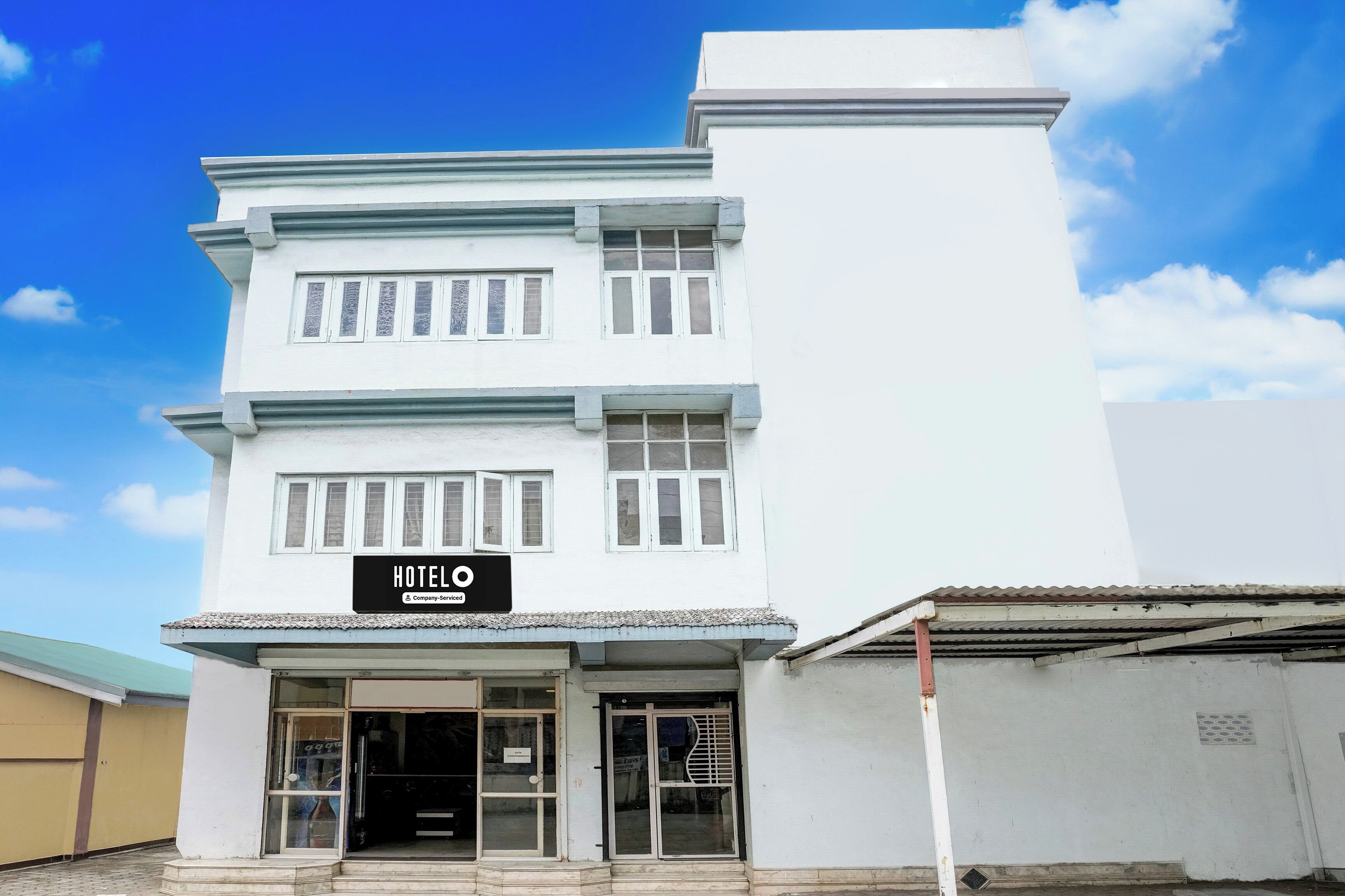 A white building with a sign that reads 'HOTEL'.