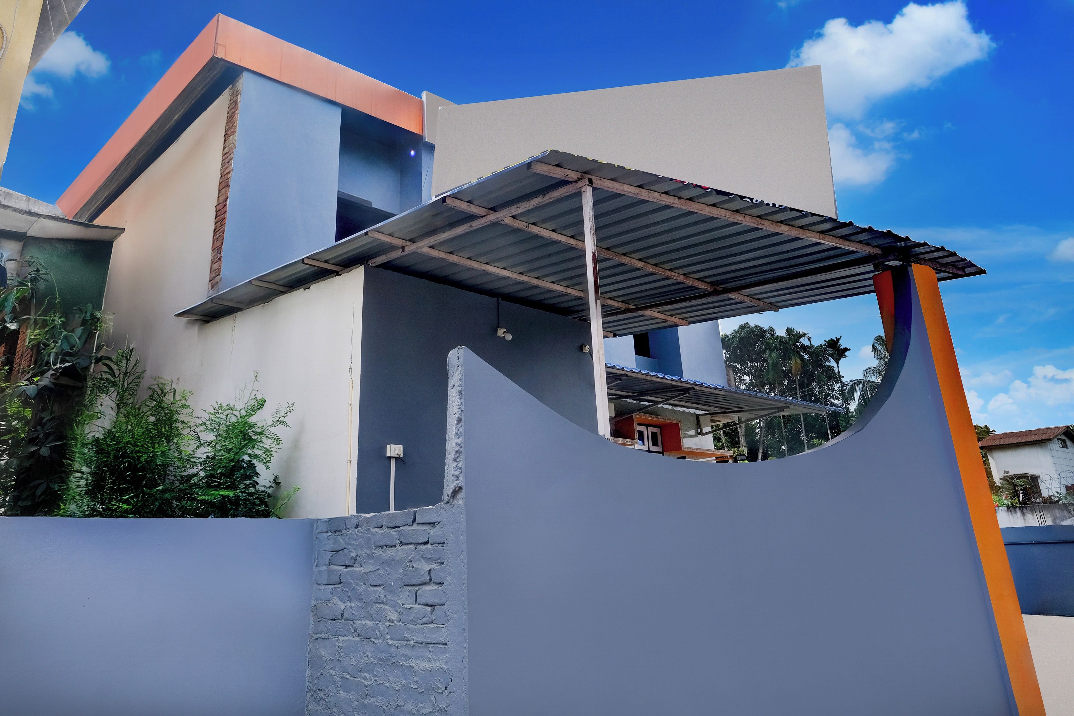 A modern building with a unique architectural design, featuring a curved wall and a metal roof structure.