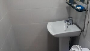 Casa de banho com sanita, lavatório e zona de duche.