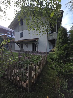 A two-story building with a balcony and a wooden fence. - Cozy vacation rental on the Guldensteig trail in the heart of the Bavarian Forest National Park (Neuschönau)