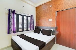 Un dormitorio con una cama, una ventana con cortinas moradas, una puerta de madera y una pared con diseño.