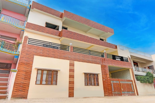 A multi-story residential building with a flat roof, balconies, and a gated entrance. - Collection O Varanasi Ashta Bhuji Temple (Varanasi)
