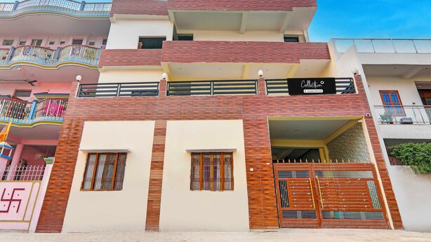 A multi-story building with a prominent signboard, a gated entrance, and a balcony with decorative railings. - Collection O Varanasi Ashta Bhuji Temple (Varanasi)
