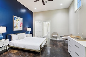 A bedroom with a bed, bedside tables, a chair, a dresser, and a ceiling fan. - Historic Bywater 2BR Near Frenchmen St (New Orleans)