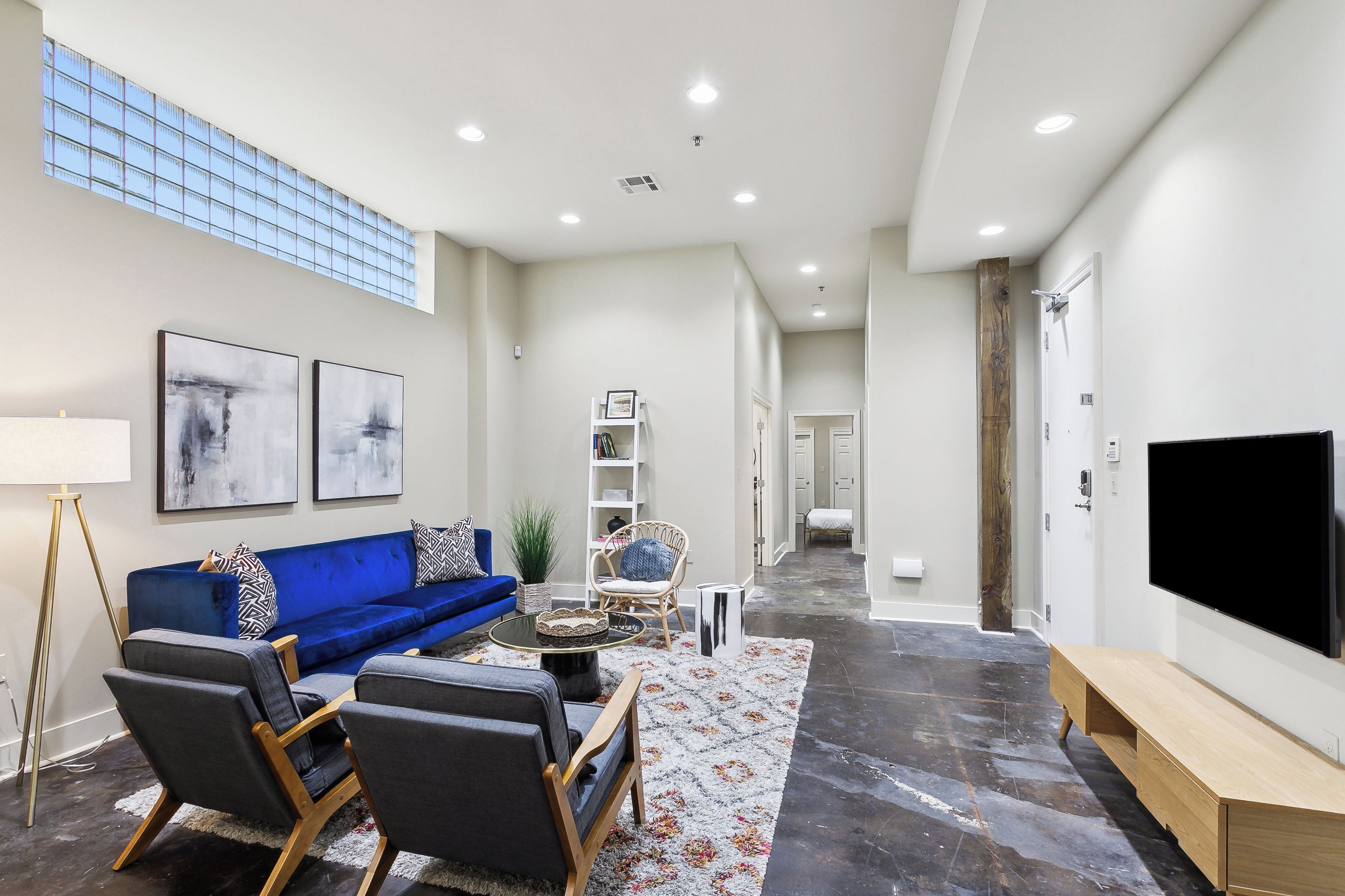 A modern living room with a blue sofa, a coffee table, and a flat-screen TV.
