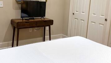 A bedroom with a bed, a bedside table, a TV, and a wardrobe.