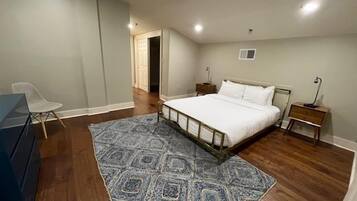 A bedroom with a bed, bedside tables, a chair, and a rug.