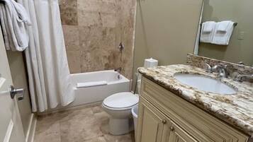 A bathroom with a shower, toilet, and sink.