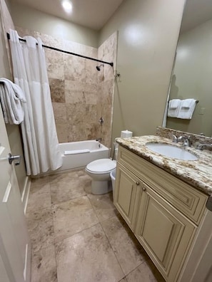 A bathroom with a shower, toilet, and sink. - Stylish 2BR condo near Frenchmen St (New Orleans)