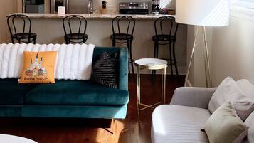 A modern living room with a sofa, a coffee table, and a lamp.