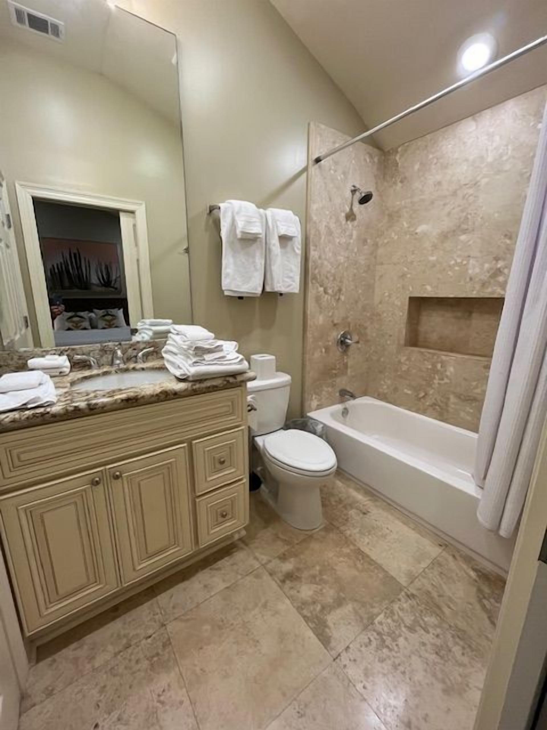 A bathroom with a vanity, toilet, bathtub, and shower.