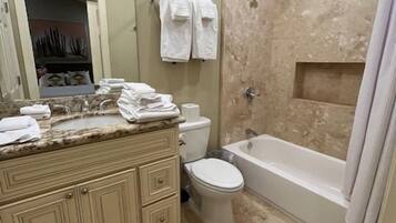 A bathroom with a vanity, toilet, bathtub, and shower.