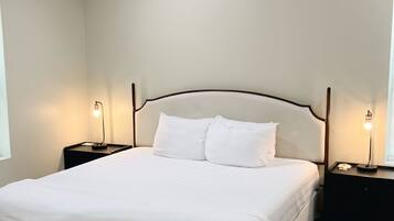 A bedroom with a bed, nightstands, and a ceiling light.