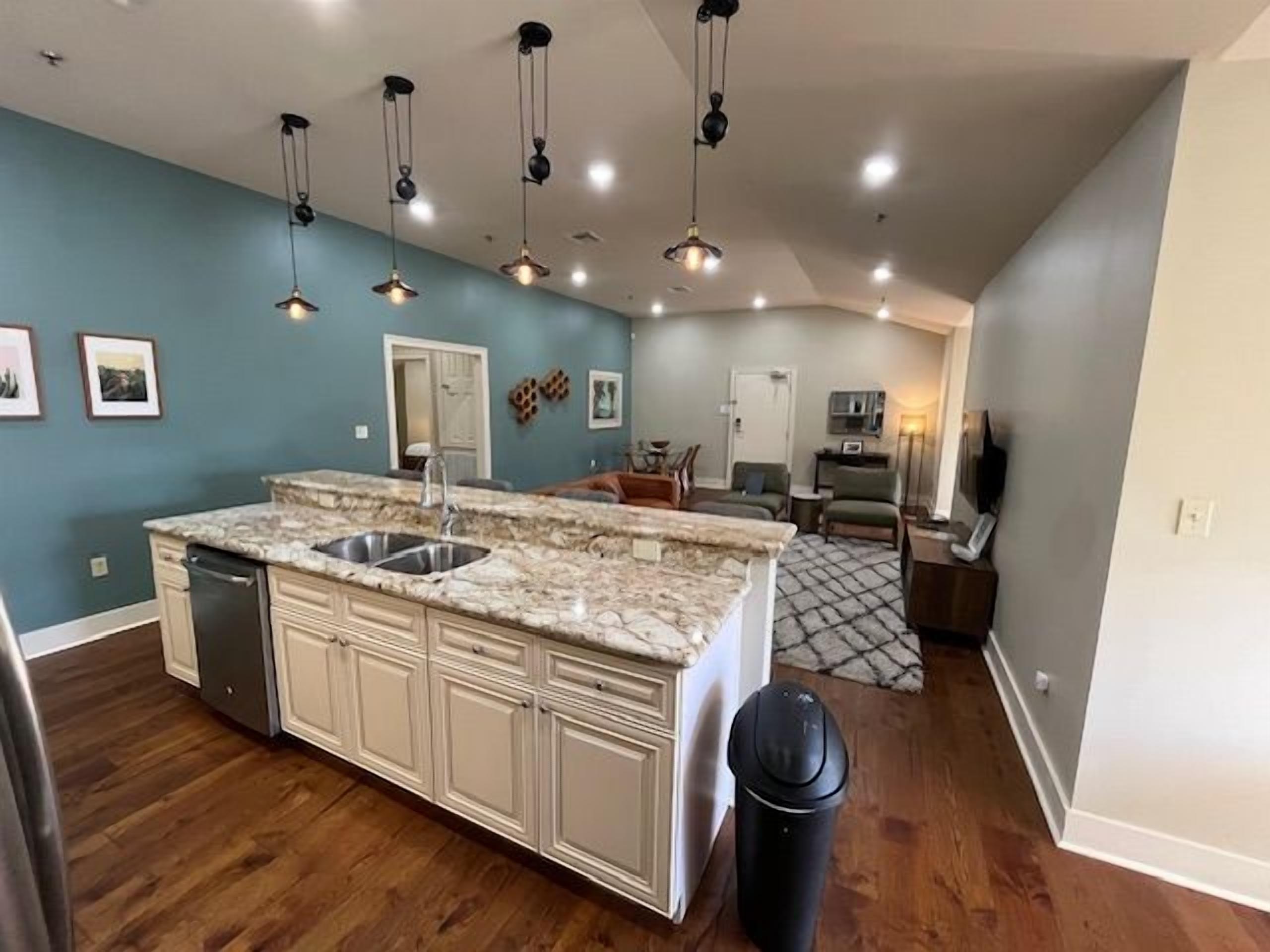 A kitchen with a central island, built-in cabinets, and a stainless steel sink.
