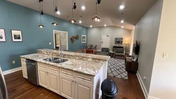A kitchen with a central island, built-in cabinets, and a stainless steel sink.