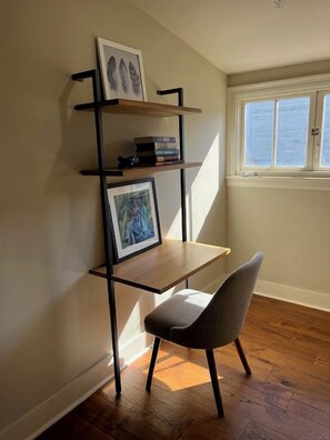 A corner workspace with a desk, chair, and shelves against a wall. - Comfortable 2BR New Orleans vacation rental in Bywater, sleeping 4 with 2 queen beds. Located at historic Burgundy & Piety, steps from Crescent Park and a short ride to Frenchmen Street & the French Quarter. (New Orleans)