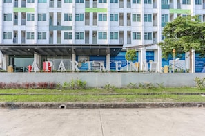 A multi-story building with a modern architectural design, featuring a prominent sign with the word 'APARTMENT' and a series of windows.