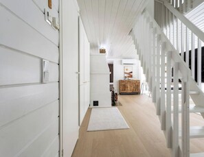 A modern interior with a staircase, wooden flooring, and a white railing. - Ylläs Kaarnikkakuja 12 by Holiday in Lapland (Ylläs)