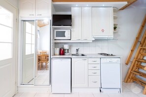 A compact kitchen with white cabinetry, a microwave, a coffee maker, and a dishwasher. - Postintie 1608 by Holiday in Lapland (Levi)