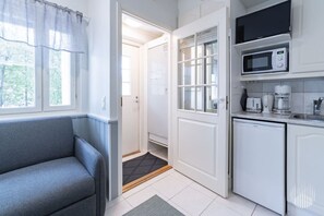 Eine kleine Küchenzeile mit Mikrowelle, Kaffeemaschine und Toaster.