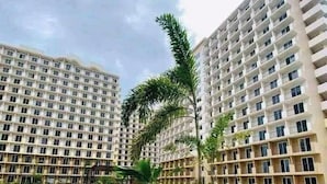 A swimming pool surrounded by high-rise residential buildings. - Oceanview Escape Steps to Shore Private Balcony (Lapu-Lapu)
