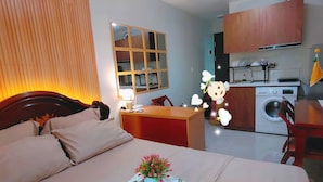 A hotel room with a bed, a desk, a small kitchen area, and a bathroom. - Oceanview Escape Steps to Shore Private Balcony (Lapu-Lapu)
