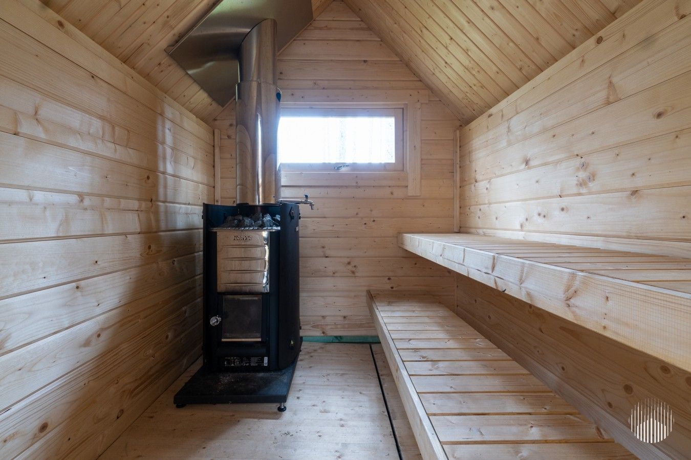 En træhytte med sauna, et vindue og en bænk.