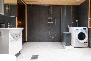 Une salle de bain moderne équipée d’une douche, d’un lavabo et d’un lave-linge.