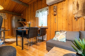 A wooden cabin interior with a dining area, sofa, and a mounted animal head. - Villa Pönttölä by Holiday in Lapland (Ruka)
