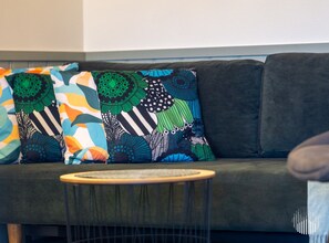 A sofa with colorful patterned cushions and a small round table in front. - Postintie 1617 by Holiday in Lapland (Levi)