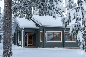 Une maison à deux étages, à l’extérieur sombre, avec un porche à l’avant et un numéro de porte bien visible, le « 11 ».