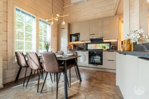 Cozinha moderna com área de refeições, janelas amplas e uma ilha central.