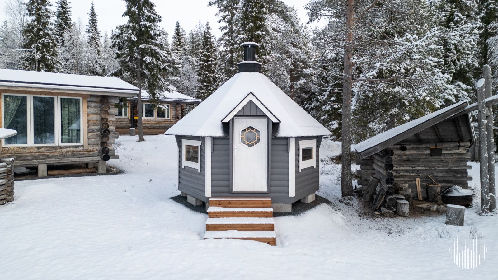 A cabin with a snow-covered roof, a wooden door, and a small porch.