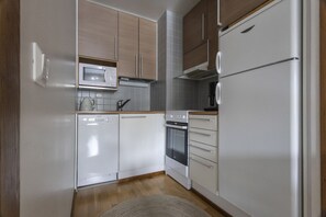 Cozinha compacta com micro-ondas, forno e geladeira.