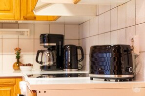 Eine Küche mit einem Toaster, einer Kaffeemaschine und einer Vase mit Blumen auf der Arbeitsfläche.