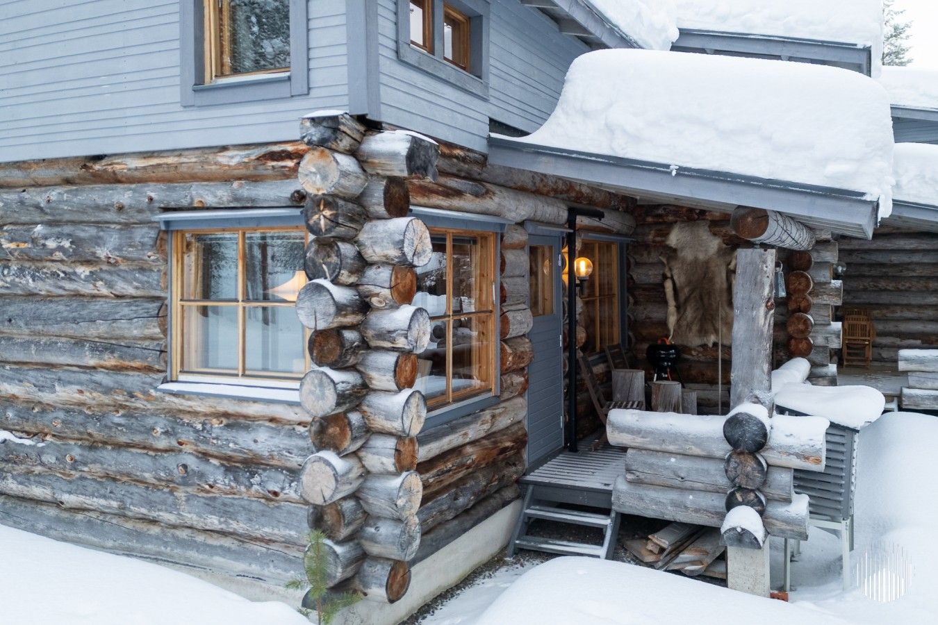 A log cabin with a porch, a fireplace, and a window.