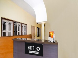 A hotel reception desk with a sign indicating it is company-serviced. - Hotel O BHU Campus (Varanasi)