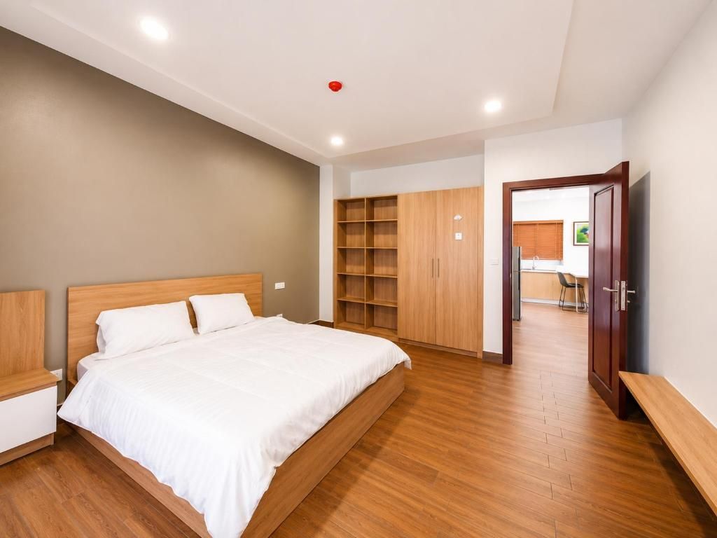 Ein Schlafzimmer mit einem Bett, einem Holzschrank und einem Fernseher.