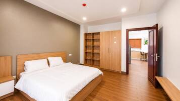 Un dormitorio con cama, armario de madera y televisor.