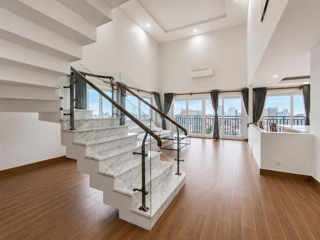 Ein modernes Interieur mit einer Marmortreppe, Blick auf die Stadt durch große Fenster und einem minimalistischen Design.