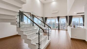 Ein modernes Interieur mit einer Marmortreppe, Blick auf die Stadt durch große Fenster und einem minimalistischen Design.