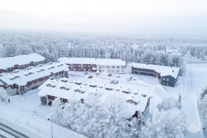 Ein mit Schnee bedeckter Gebäudekomplex mit mehreren Gebäuden, Parkplätzen und einer Straße.