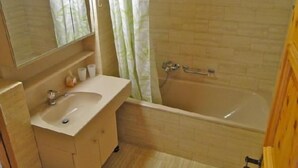 Un baño con lavamanos, espejo y bañera.