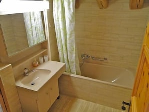 Ein Badezimmer mit Waschbecken, Spiegel und Badewanne.