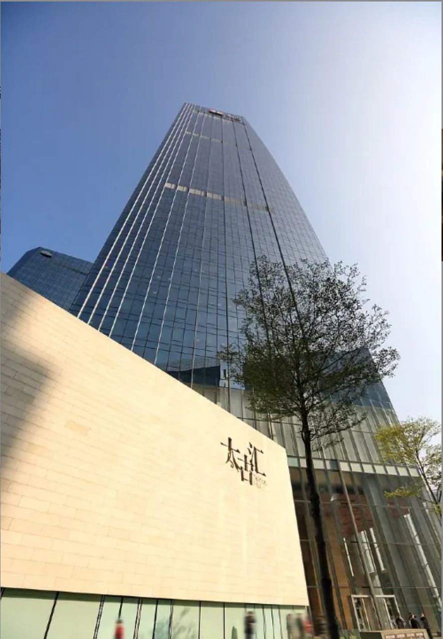 A modern building with a glass facade and a prominent sign.