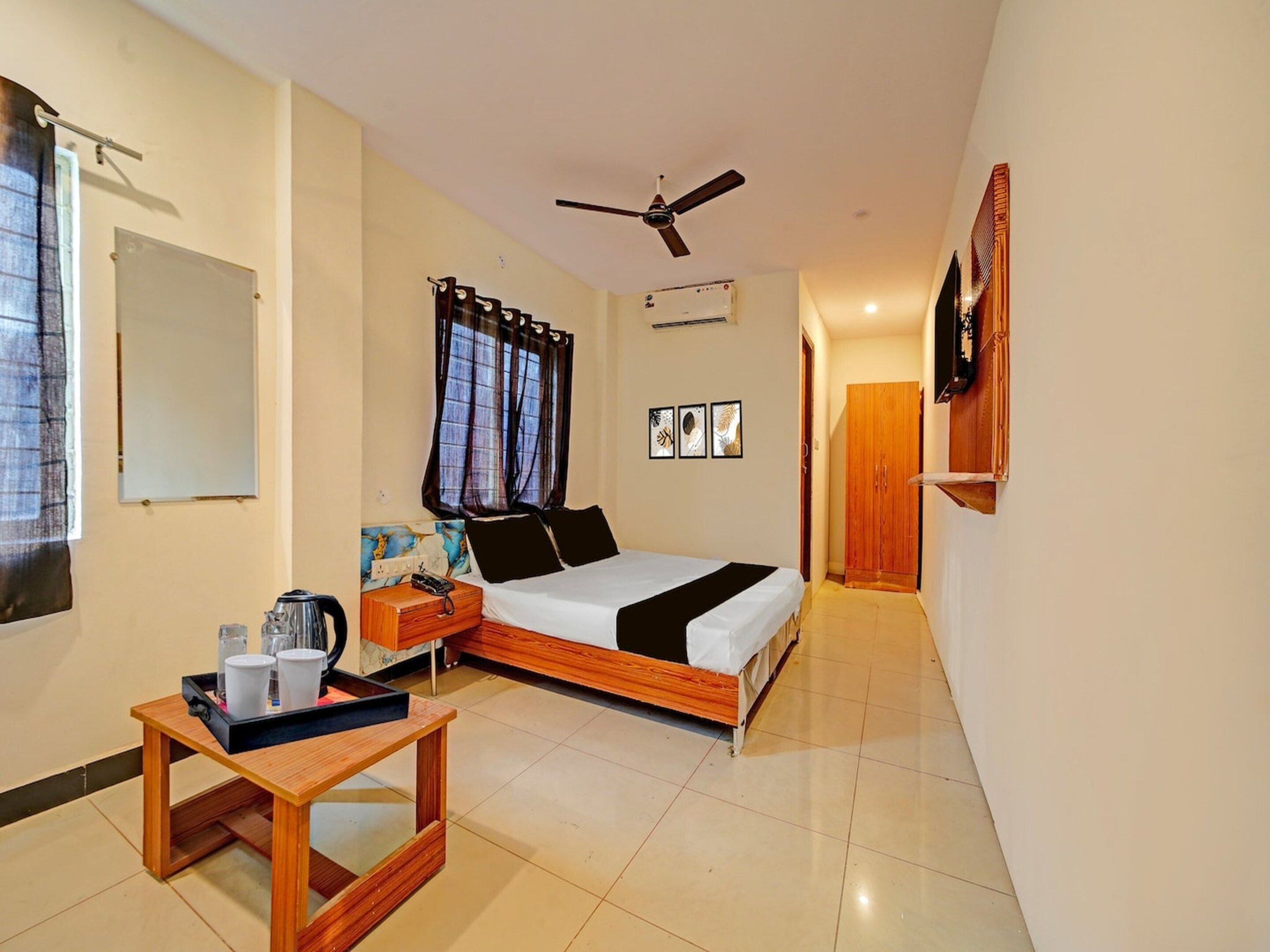 A bedroom with a bed, a desk, a chair, a ceiling fan, and a wardrobe.