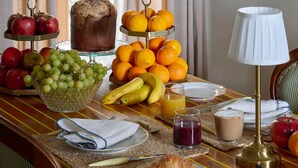 Una colazione con frutta, un croissant e bevande su un tavolo.