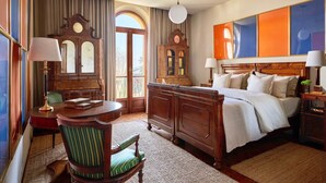 Una camera d'albergo con un letto, una scrivania, una sedia, un armadio e un'ampia finestra.