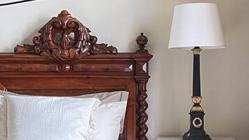 A bed with a wooden headboard, a bedside lamp, and a nightstand.